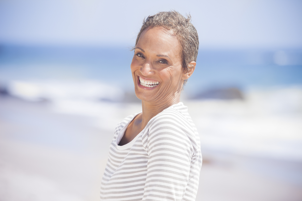 Senior African American Woman Smiling on Beach with Sculptra Aesthetic dermal filler