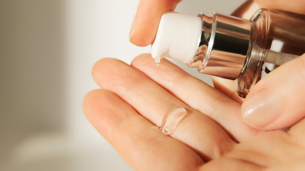 Push dispenser liquid facial fluid gel squeezed out to hand.