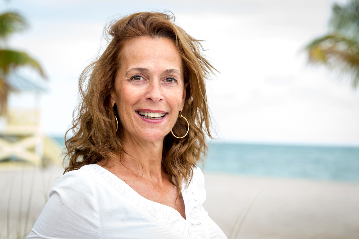 middle aged women who has had a facelift - standing outside near the beach